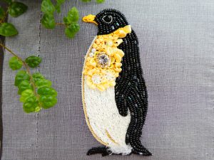 ペンギンのブローチです。胸元に大きなクリスタルとリボン刺繍があり華やかな感じです。