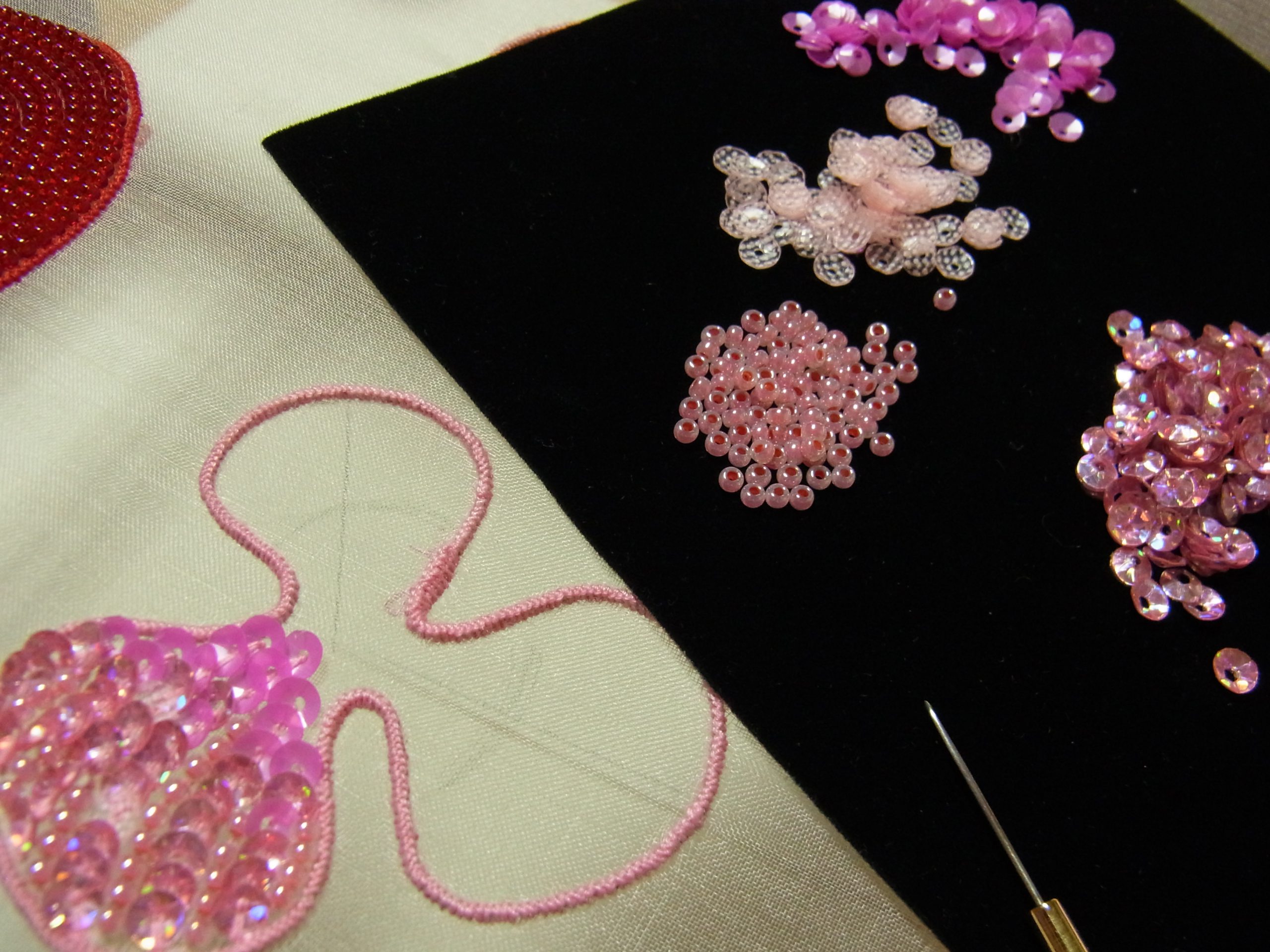 ピンクの花のチャームを、4種類の材料で刺しています