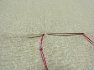 ビーズの幅で生地をすくったら、最初の糸の部分に針を戻します