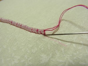 最後のビーズの糸部分に針を入れ、生地の裏側で玉止めをします