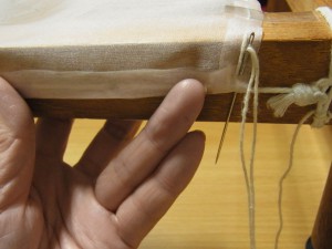 生地を折り返して、木枠の糸部分に縫いとめています。