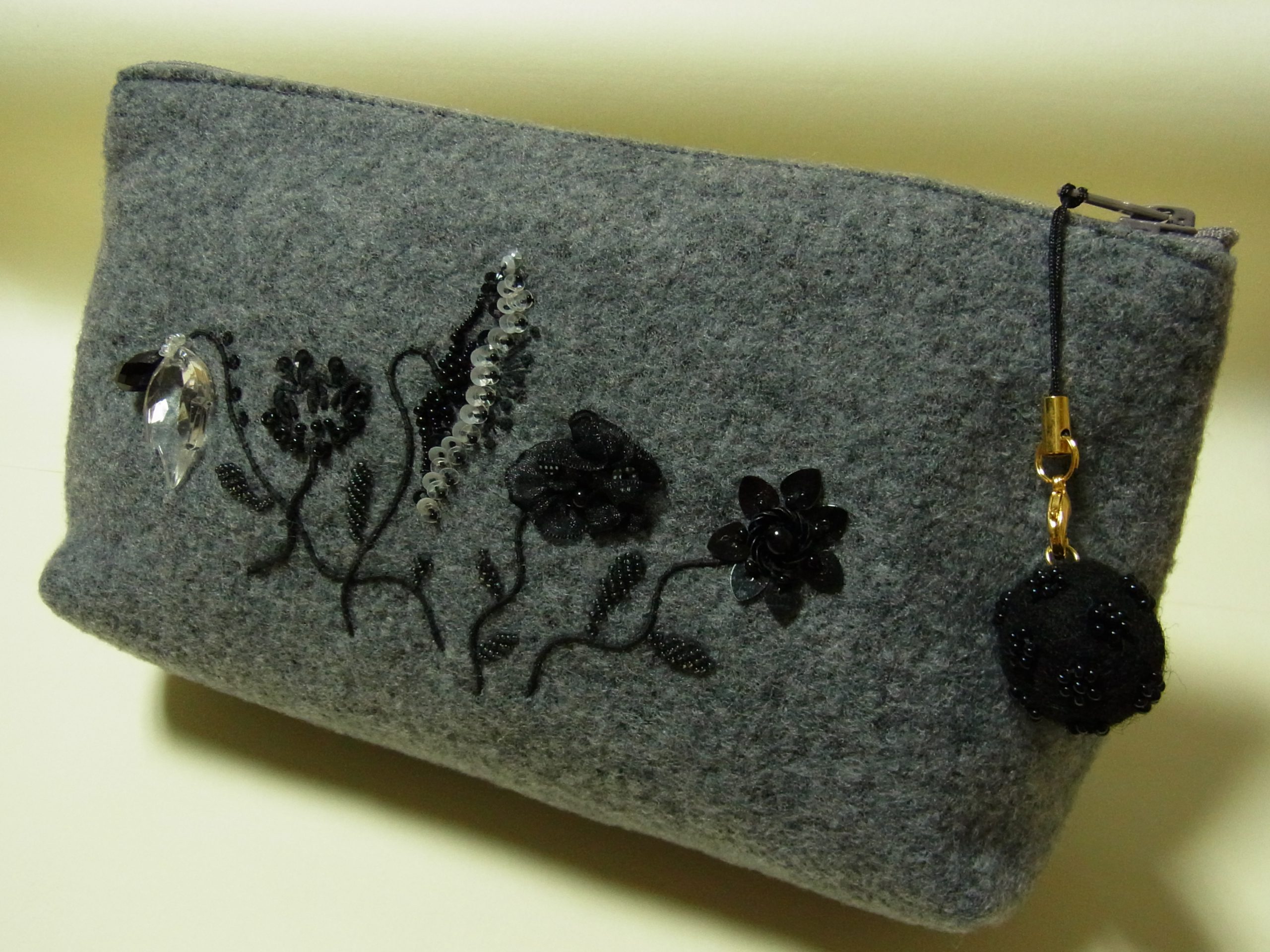 5種類の花が刺繍されているグレーのポーチです。