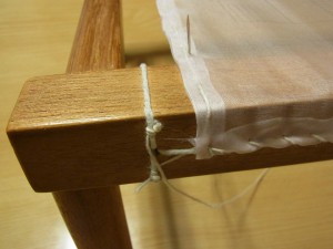 横棒の糸に針を2～3回通して、しっかり糸をしめます。針を、横棒の下を通し縦方向の縫い目の際に出します