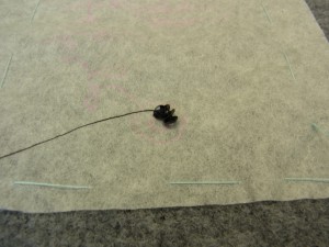 ポーチの右端のお花、中心部分から刺しています。スパンコールの連続刺し（円形）です。