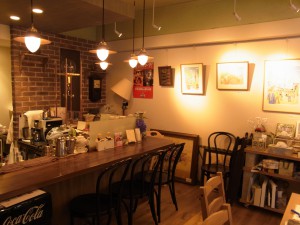 cafeの写真です。絵画が飾ってあり、レトロな照明が店内を照らしています。
