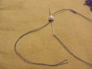 パールから糸が出ている側から針を入れて抜きます。