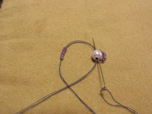 パールから糸が出ている側から、針を通して抜きます。