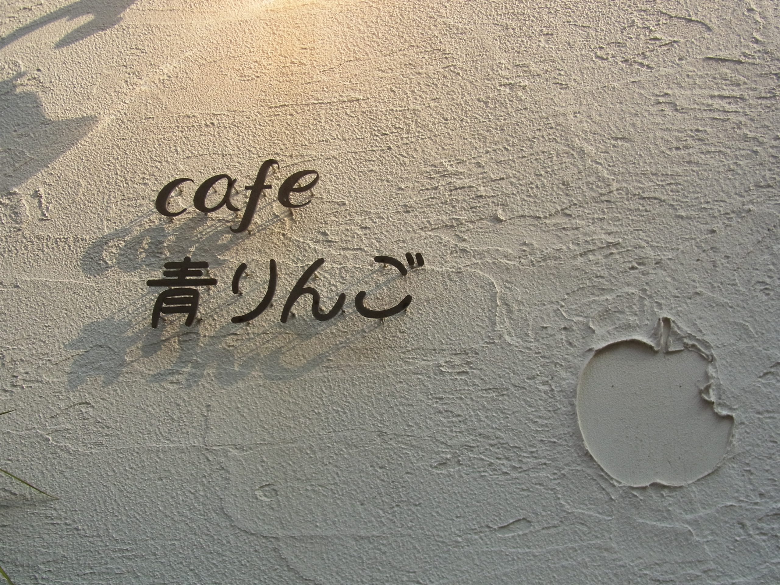 cafe 青りんごの看板です。りんごの模様が壁に付いています。