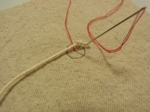 中心から糸を出してタコ糸をまたいで、今出ている糸の側に針を落とします。