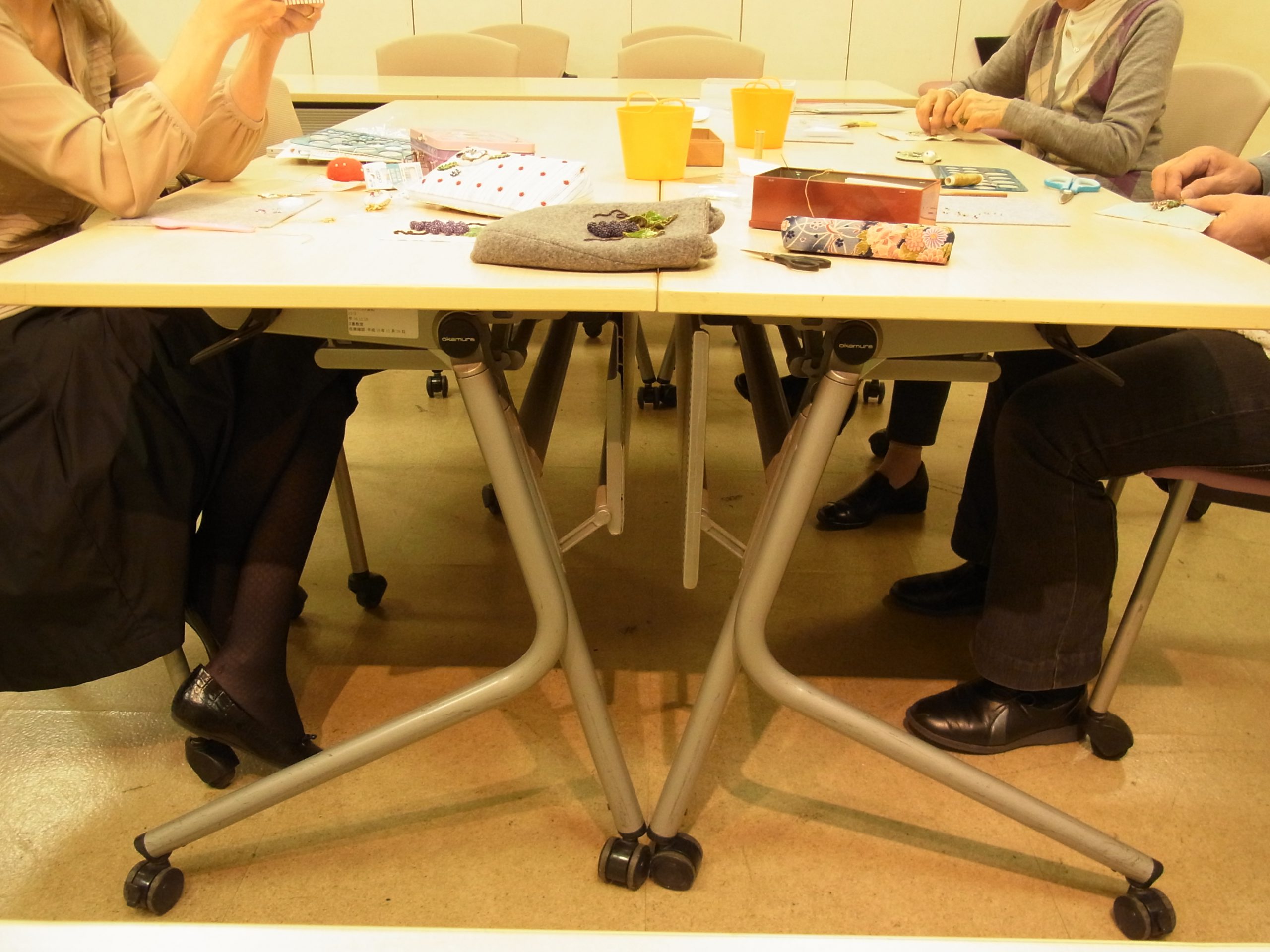 3名の方がテーブルを囲んでビーズ刺繍をしています。