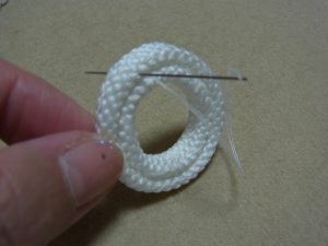 2重にした紐を2本取りの糸で止めていきます。