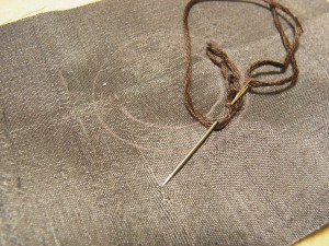 円形ブローチの下部、3分の2くらいの部分に刺繍糸でチェーンステッチをしています。