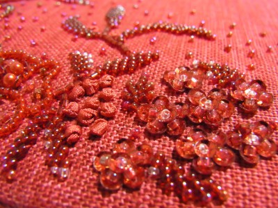 メインの赤い花の右上に刺繍されている数々の可愛い小花。リボン刺繍のテクニックも取り入れました。
