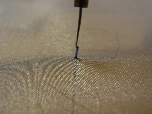 糸が、針先から外れないように注意しながら糸を引っ張り、締めて玉止めを完成させます。